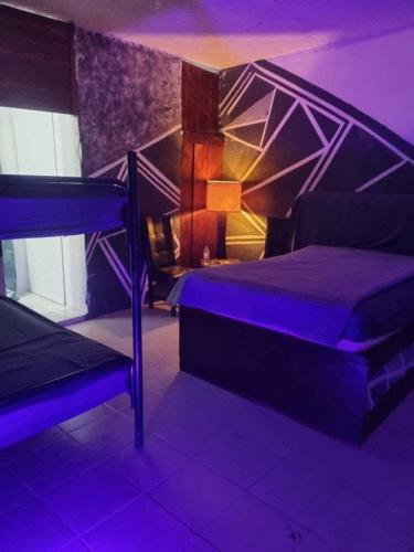 a bedroom with a bed with purple lighting at Bolet in Monterrey
