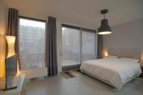 een slaapkamer met een bed en een groot raam bij Zandstudio in Alkmaar