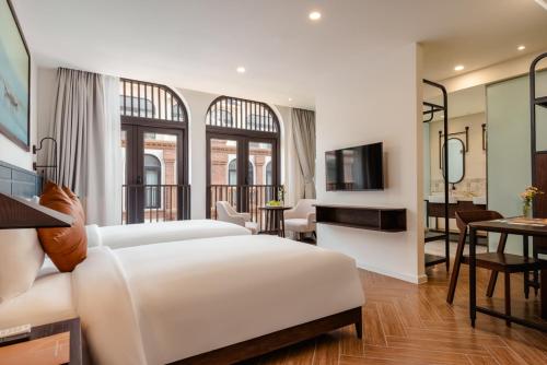 a bedroom with a bed and a living room at Lumiere Boutique Vỹ Dạ in Thôn Lại Thê