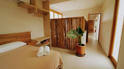 a bedroom with a bed and a potted plant at Aguamiel Agua Blanca in Playa Agua Blanca