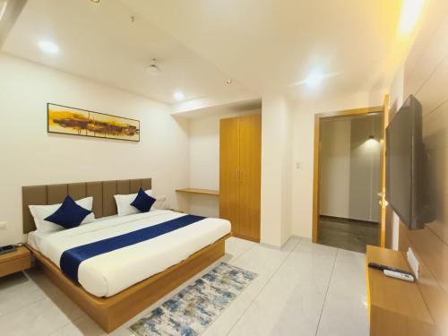 a bedroom with a large bed with blue pillows at hotel vistara luxe in Himatnagar