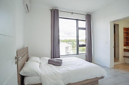 a bedroom with a bed with a large window at Ebene City Centre - 2 Bedroom Apartment in Ebene