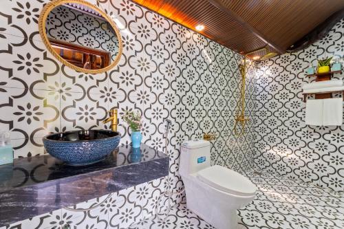 a bathroom with a toilet and a sink and a mirror at Wooden chill house in Hoi An