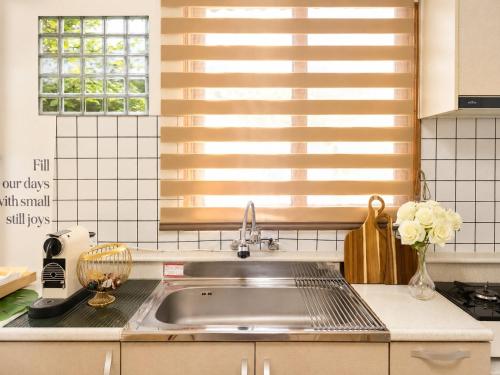 a kitchen with a stainless steel sink and a window at 수원 화서역 편한 집 in Suwon