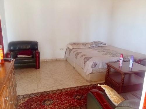 a bedroom with a bed and a chair and a table at Baraka Nema Villa Resorts in Gunjur