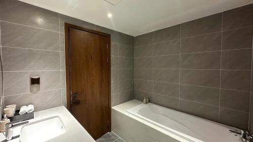a bathroom with a bath tub and a sink at The Dome Grand in Ninh Lão