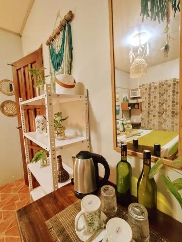 a kitchen with a table with two bottles of wine at Amwani Garden Pool & Kubo in Puerto Princesa City