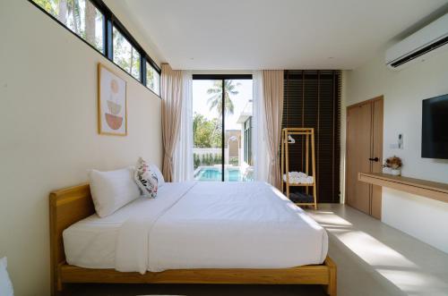 a bedroom with a bed and a large window at Radarin Villa in Ban Khao Kloi