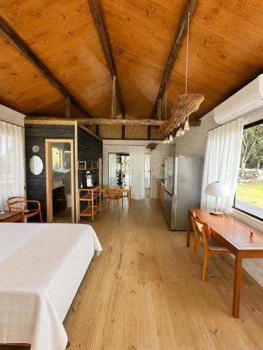 a bedroom with a bed and a table and a kitchen at Celeiro in Campina Grande do Sul