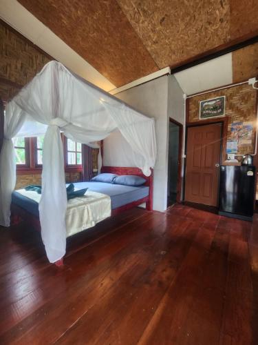 a bedroom with a bed with a canopy at Mook Bamboo Bungalows in Ko Mook