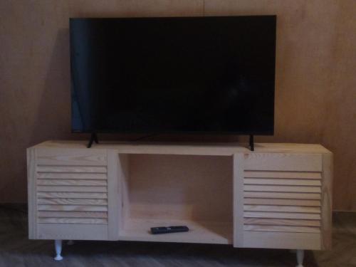 a television on top of a white entertainment center at Ada chalet in Mărăcineni