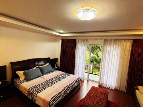 a bedroom with a bed and a large window at The Transient Villa Hotel and Suites in Cordova