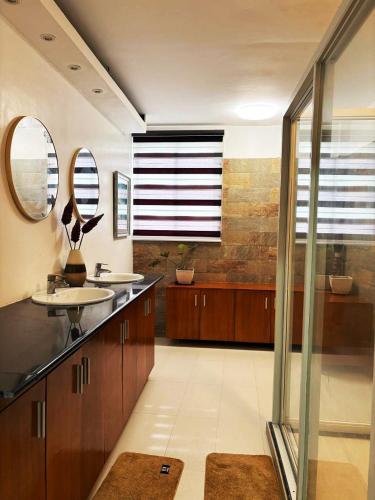 a bathroom with two sinks and two mirrors at The Transient Villa Hotel and Suites in Cordova