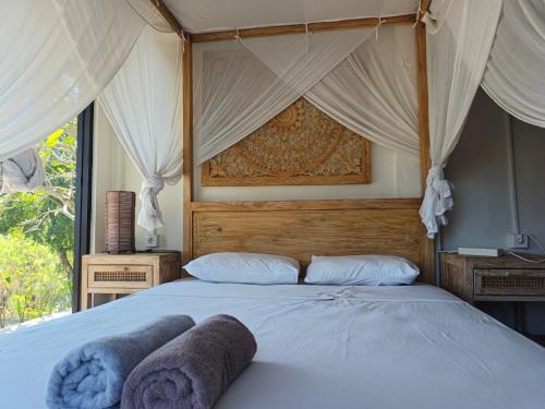 a bedroom with a bed with a canopy at Maluk House in Taliwang