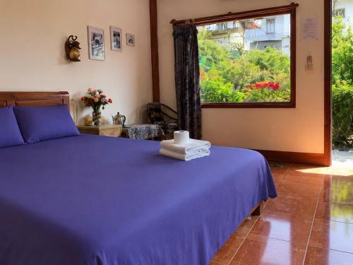 a bedroom with a purple bed and a window at Sapa Tatu Homestay in Sapa