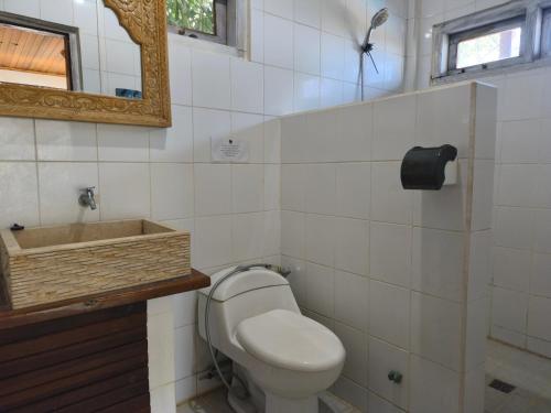 a bathroom with a toilet and a sink and a mirror at Maluk House in Taliwang