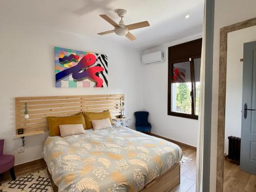 a bedroom with a bed and a ceiling fan at Villa Pins by Costabravaway in Llagostera