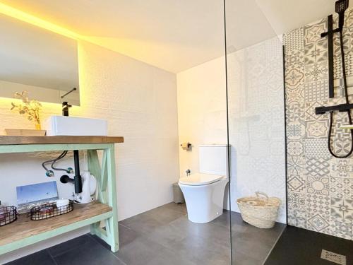a bathroom with a toilet and a glass shower at Villa Pins by Costabravaway in Llagostera