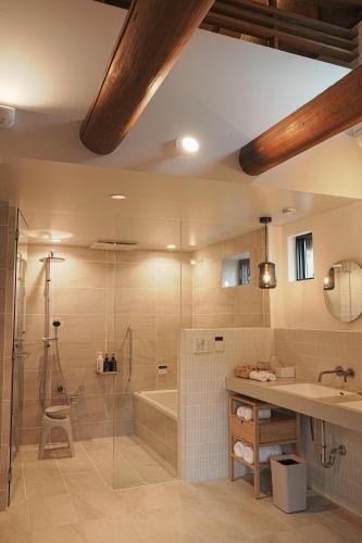 a bathroom with a shower and a tub and a sink at TOKIWA葛城-katsuragi- in Shinjō