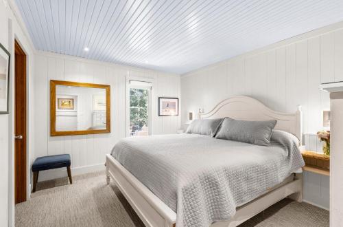 a white bedroom with a bed and a mirror at 3584 Shipwatch Rd in Kiawah Island