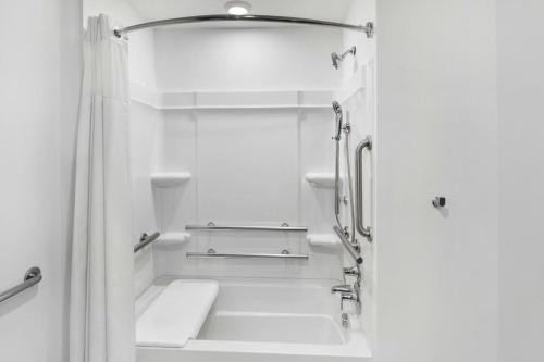 a white bathroom with a shower and a sink at StudioRes by Marriott Leland in Leland