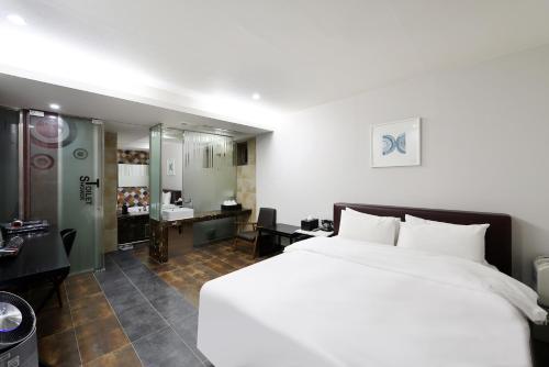 a bedroom with a large white bed and a bathroom at Hip Hotel in Seoul
