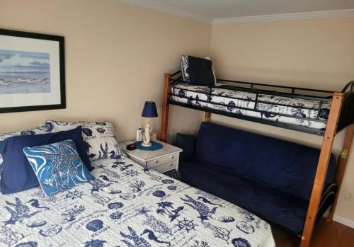 a bedroom with two bunk beds and a night stand at Cozy Condo in Seaside Heights