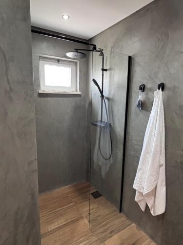 a shower with a glass door in a bathroom at Casa 26 in Olhão