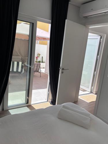 a bedroom with a bed and a view of a balcony at Casa 26 in Olhão