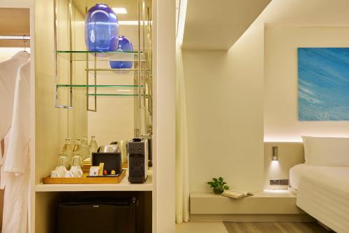 a bathroom with a shelf with blue glass bottles at Pullman Pattaya Hotel G in North Pattaya
