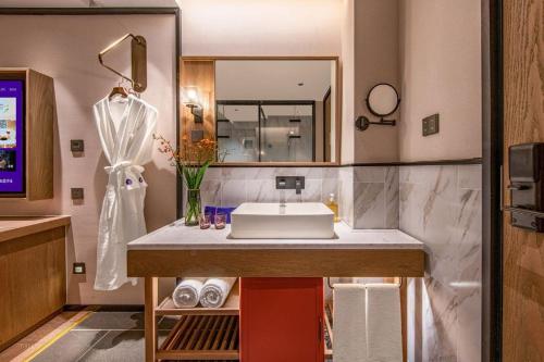 a bathroom with a sink and a mirror at Manxin Hotel Nanjing Mufu Mountain in Nanjing