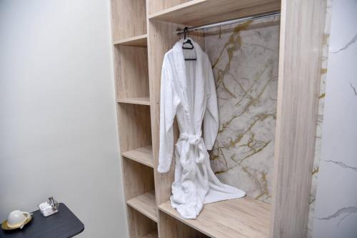 a robe hanging on a wooden shelf in a bathroom at The Premier Comfort in Nairobi