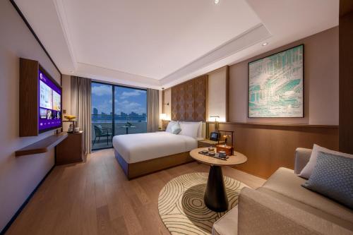 a hotel room with a bed and a tv and a couch at Manxin Hotel Nanjing Mufu Mountain in Nanjing