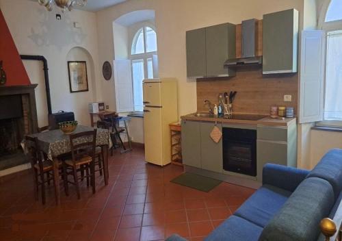 a kitchen and living room with a couch and a table at Casa di Anchiano in Borgo a Mozzano