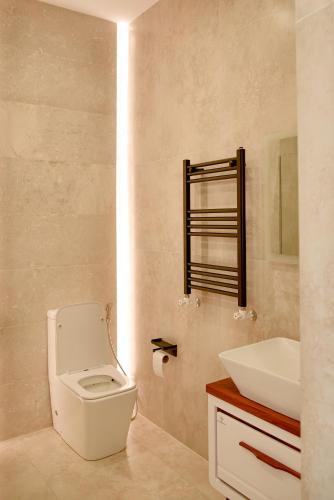 a bathroom with a white toilet and a sink at Arinest Villa with heated pool, 20 min from Yerevan in Elar