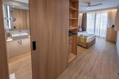 a bathroom with a sink and a mirror and a room at GHT Oasis Tossa & Spa in Tossa de Mar