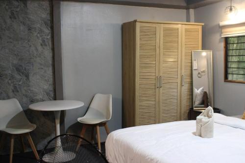 a bedroom with a bed and a table and chairs at Charlotte place in El Nido