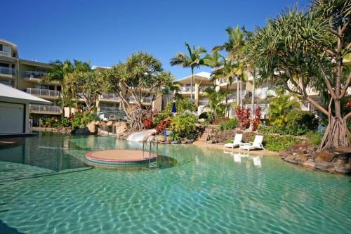a swimming pool with chairs in a resort at Alex Beach Resort 3BR Apt 428 in Alexandra Headland