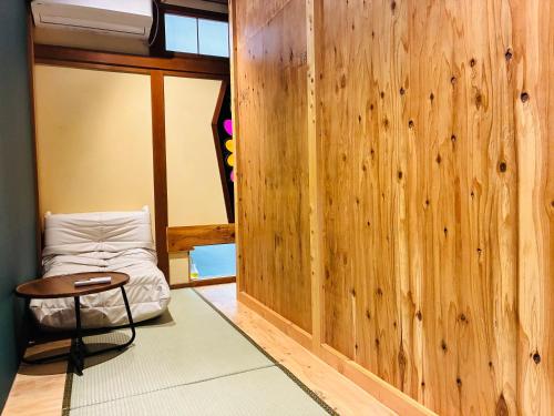 a room with a bed and a table and a chair at Guest house Mitaki in Hiroshima