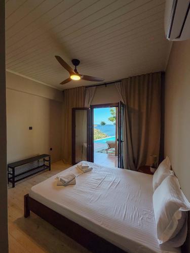 a bedroom with a bed and a ceiling fan at Summer Palace Evia in Petriaí