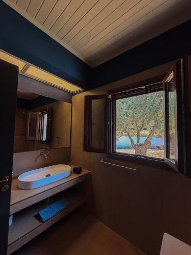 a bathroom with a bath tub and a window at Summer Palace Evia in Petriaí