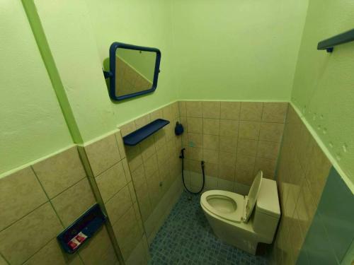 a bathroom with a toilet and a mirror at Pornaree Hotel in Ban Pak Ba Ra