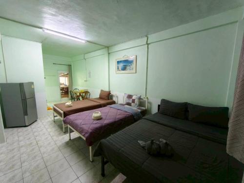 a living room with two beds and a couch at Pornaree Hotel in Ban Pak Ba Ra