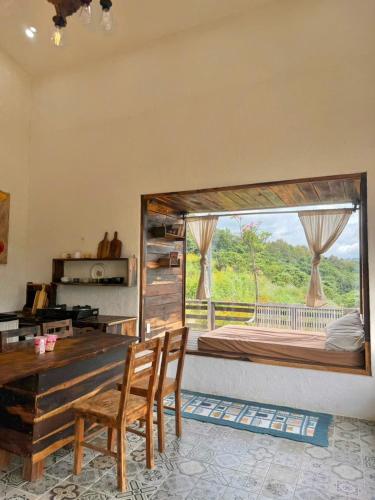 a bedroom with a large bed with a large window at Đồi Ông Thoại Cottage in Bảo Lộc