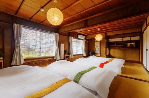 a bedroom with two beds with white sheets at 古民家おにぎり in Otsu