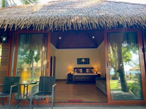 a resort room with a bed and a thatch roof at Mali Resort Pattaya Beach Koh Lipe in Ko Lipe