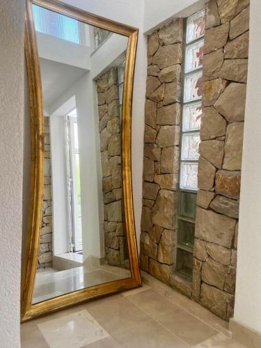 a mirror in a room with a stone wall at Villa Bougenvilia Tomas in Tučepi