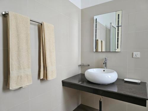 a white bathroom with a sink and a mirror at Sunrise Staycation in Katuneriya