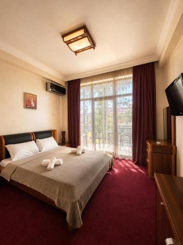 a bedroom with a bed and a large window at Antika Hotel in Batumi