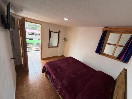 a room with a bed and a window and a television at Hotel Mirador Creel in Creel